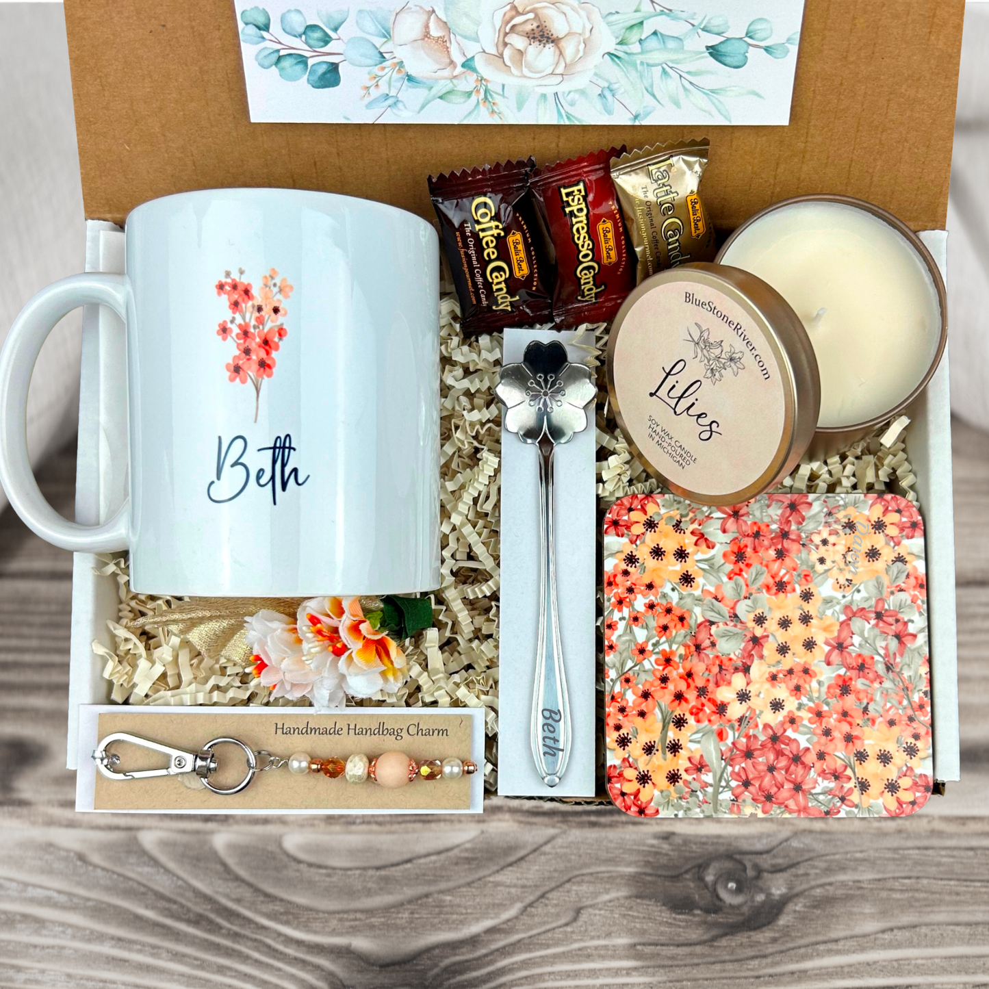  gift basket with a blush floral personalized coffee mug, engraved spoon, vibrant coaster, scented candle, artisan charm, and coffee treats for women’s