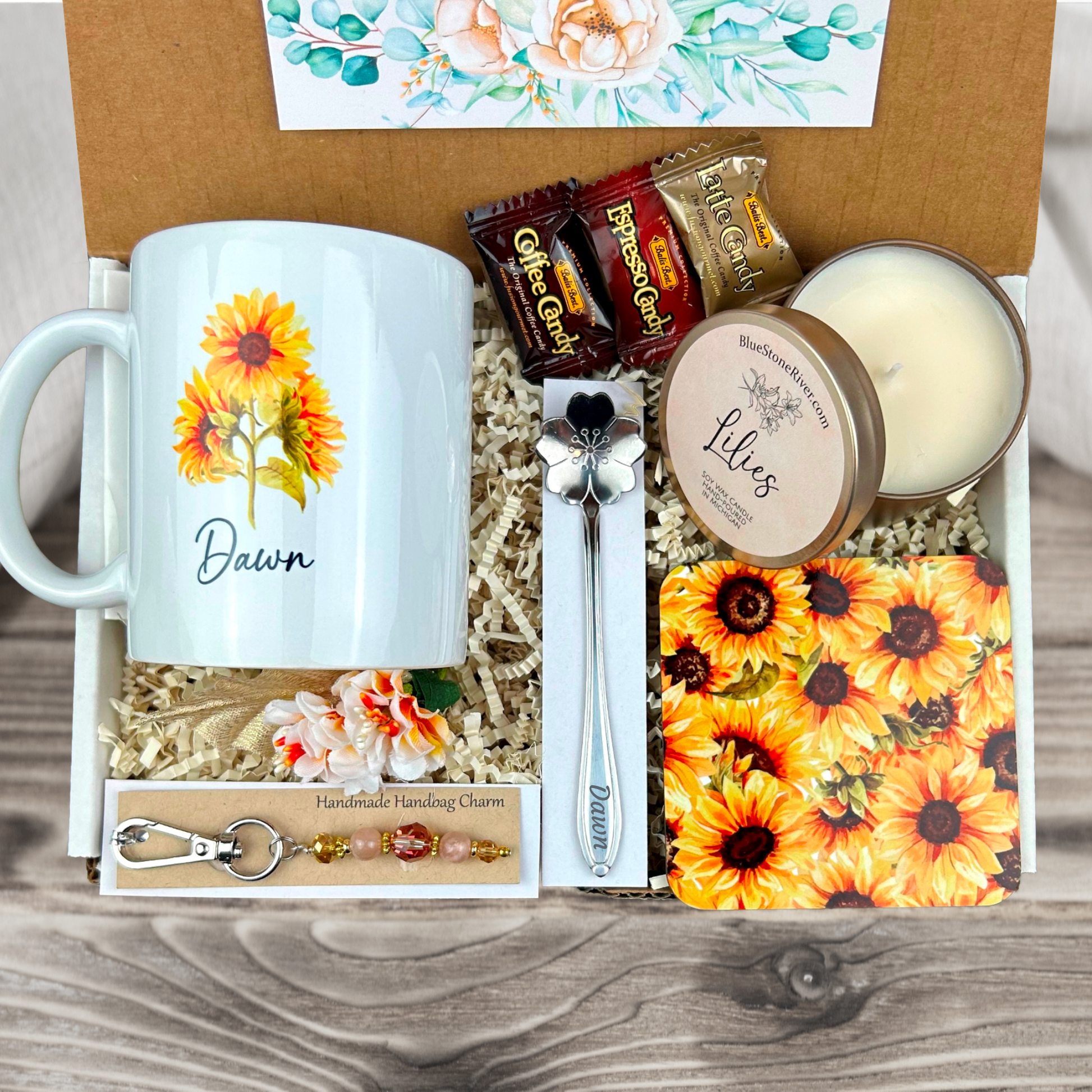  gift basket with a personalized sunflower coffee mug, engraved spoon, vibrant coaster, scented candle, artisan charm, and coffee treats for women’s present