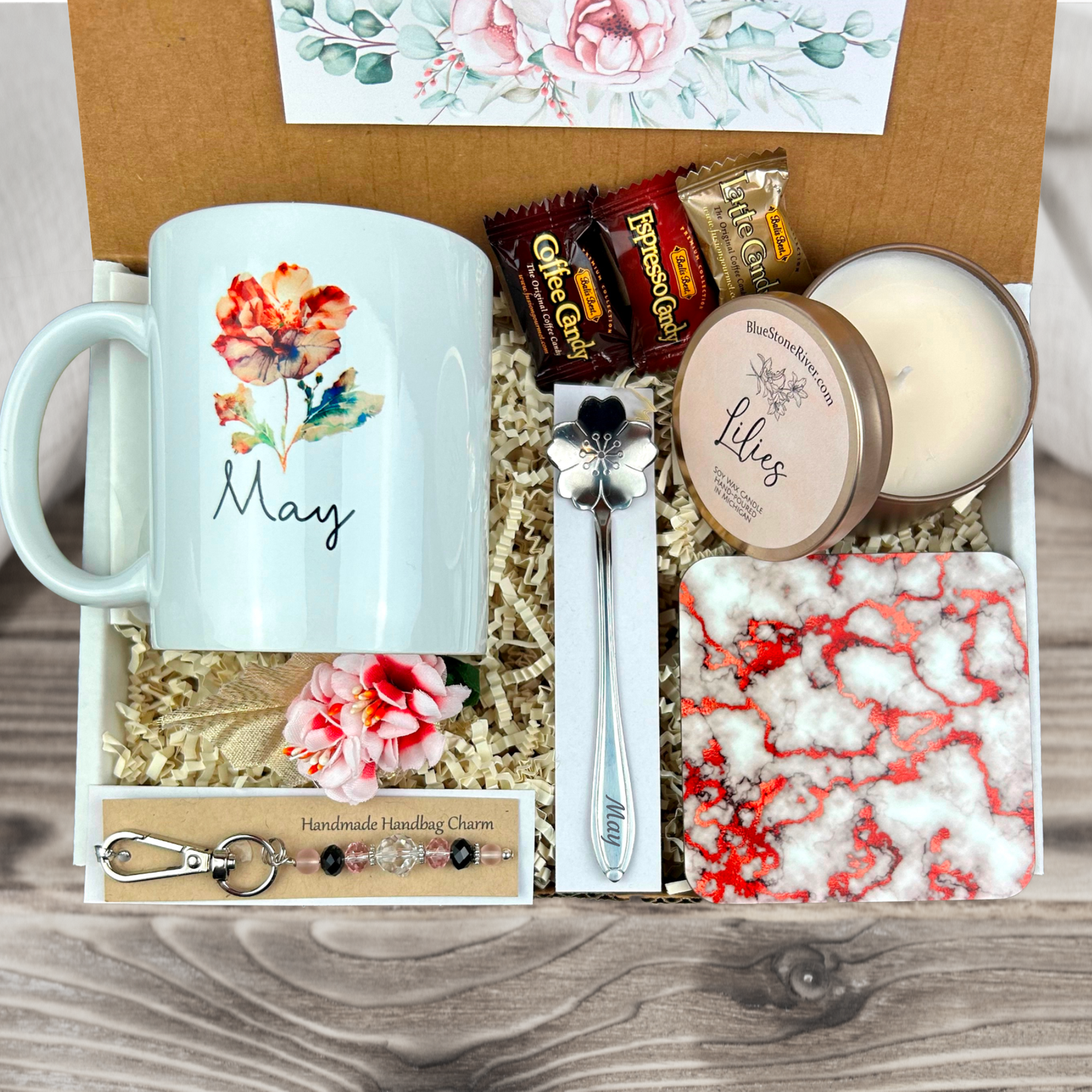 gift basket with a personalized watercolor blossom coffee mug, engraved spoon, vibrant coaster, scented candle, artisan charm, and coffee treats for women’s